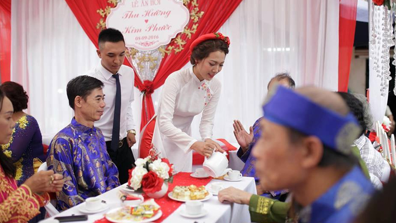 Cô dâu đi rót trà mời khách để chung vui với gia đình