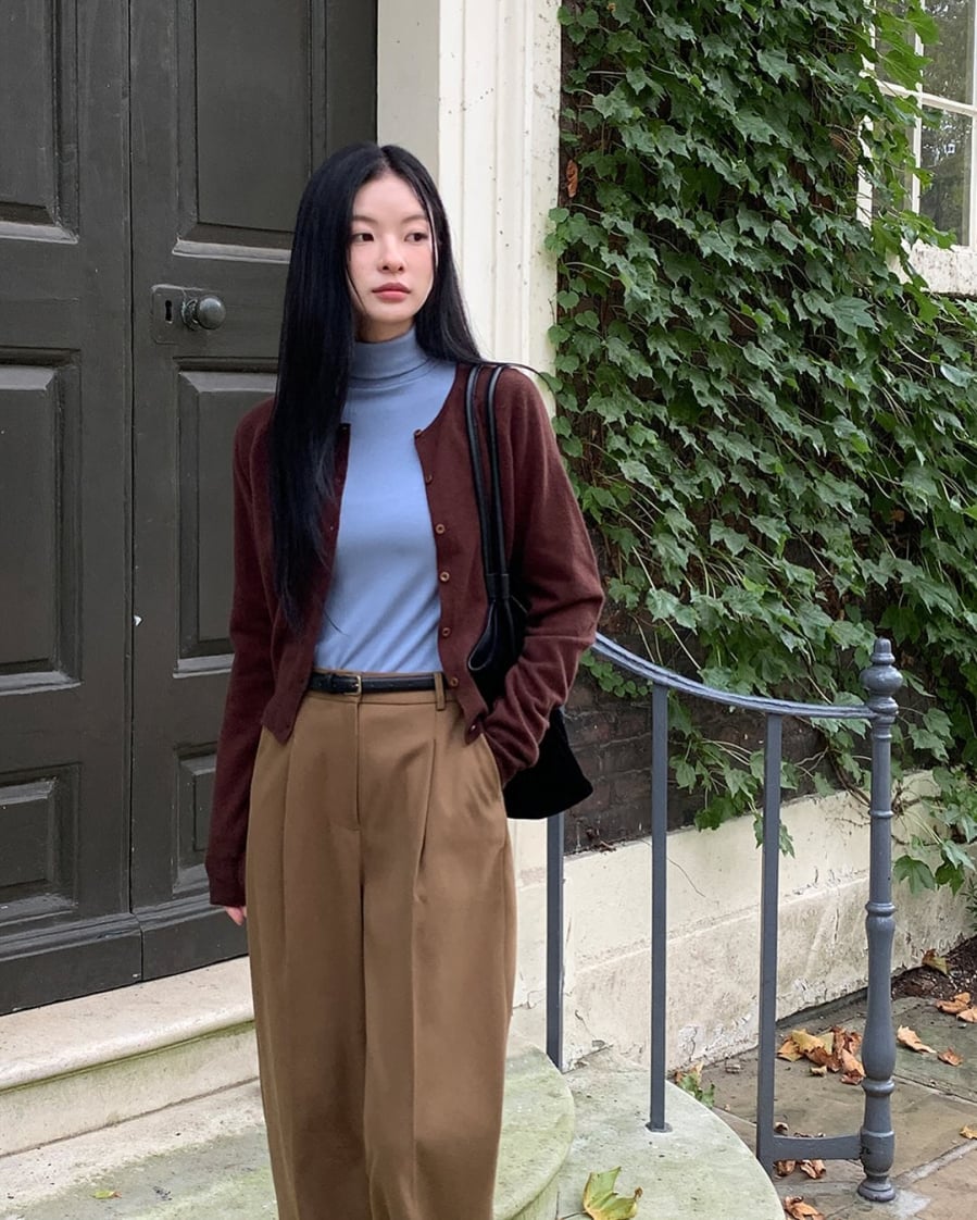Áo thun xanh pastel cùng cardigan nâu và quần be tạo nên bộ đồ hài hòa và trẻ trung.
